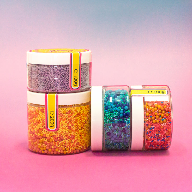 SPRINKLED sprinkles mix standing and laying sideways on purple to pink gradient background 