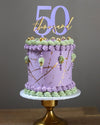 purple & green cake showing the purple & gold social media milestone cake topper zoiandco