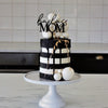 black & white cake showing the badass mom cake topper zoiandco